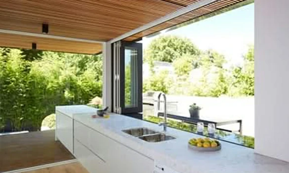 Aluminum bifold kitchen pass-through window connecting indoor kitchen and outdoor dining area