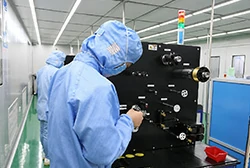 Operator inspecting bonding wire winding equipment in cleanroom