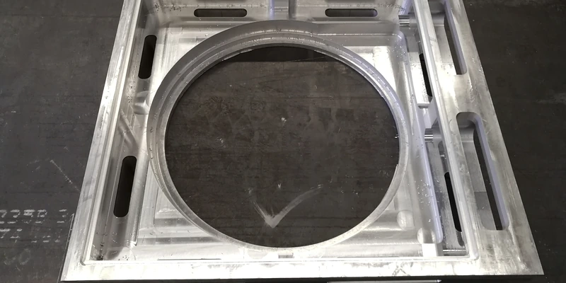 Rectangular machined aluminum component with a large circular cavity